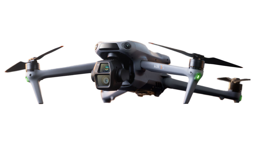 DJI Air 3S Drohne im PNG Format ausgeschnitten, sodass der Hintergrund weg ist und nur die Drohne erscheint. Die Drohen wird in einem leicht schrägen Winkel frontal gezeigt, sodass das Kameramodul gut sichtbar ist. Die Drohne ist im ausgeklappten Zustand, die Propeller sind montiert. Bereit um abzuheben.