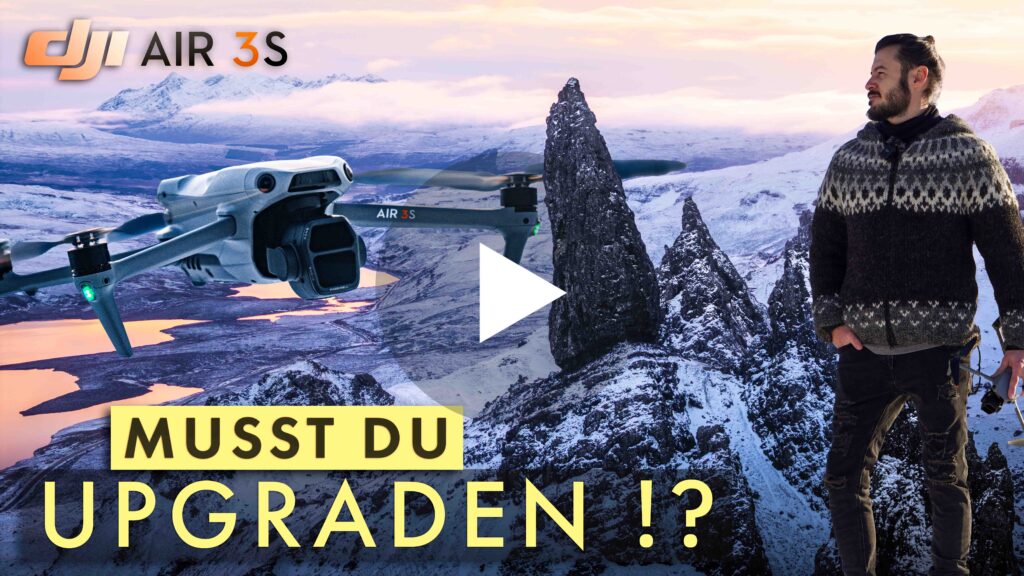 Das Youtube Thumbnail von Himmelwerke zum DJI Air 3S Test-vVdeo auf YouTube. In der Mitte befindet sich ein Play-Button um das Video zu starten. Im Bild sind Martin von Himmelwerke, die DJI Air 3s sowie das Logo der DJI Air 3S und der Schriftzug "Musst du upgraden!?" in einer Schneelandschaft in Schottland zu sehen.