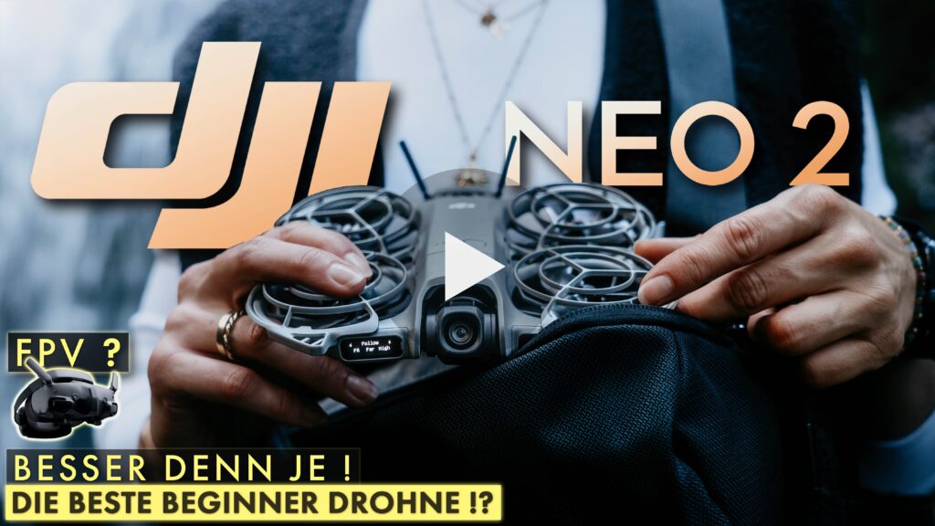 Ein Himmelwerke Bild zum DJI Neo 2 Test. Das Himmelwerke YouTube Video Thumbnail zur DJI Neo 2. Das Logo DJI NEO 2 ist in knalligem Orange zu erkennen. Eine junge Frau hält die Drohne vor sich in beiden Händen und es scheint so. als ob sie sie gerade aus der darunter liegenden Tasche geholt hätte. Das kleine Display in der Front der DJI NEO 2 leuchtet und zeigt den aktuellen Flugmodus Follow an. Im unteren linken Bildteil sieht man eine DJI Goggle 3 und darüber steht FPV? und unterhalb steht noch: Besser denn je! Die beste Beginner Drohne !? Das Gesicht der Frau ist nicht zu erkennen. Der Fokus liegt auf der Drohne und den Händen.